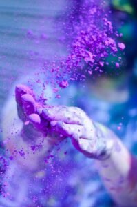 pexels photo 1927595 1927595 Close-up of hands throwing vibrant purple powder outdoors, capturing motion and color.