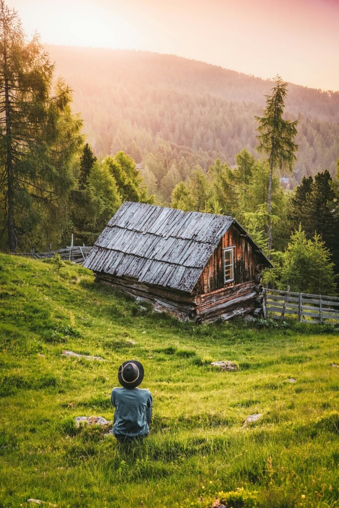pexels photo 2832034 2832034 A serene landscape featuring a wooden cabin, lush forest, and vibrant sunset.